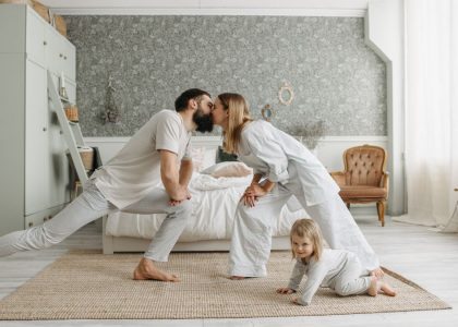A family enjoying playful bonding moments in a stylish, minimalistic bedroom setting.